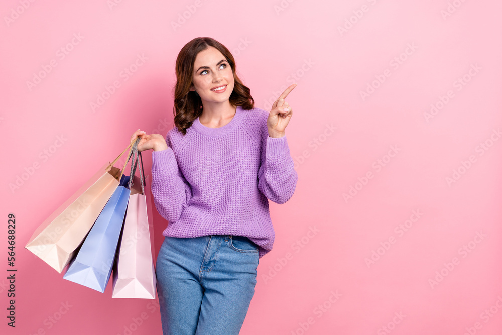 Photo of dreamy sweet lady wear violet sweater looking pointing empty space holding shoppers isolated pink color background