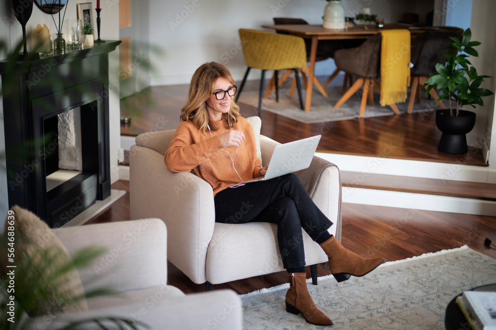Middle aged woman sitting at home and having video call Middle aged woman sitting at home and having video call