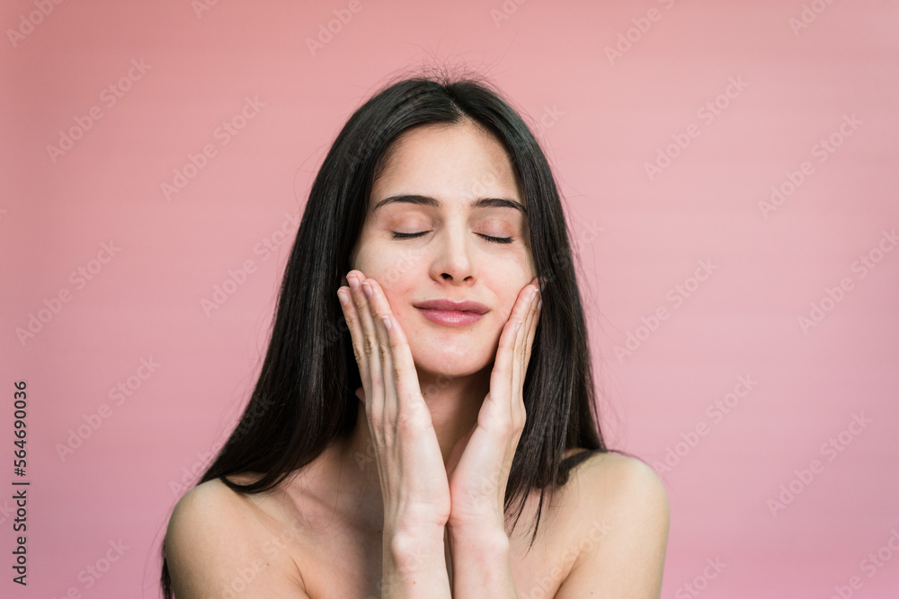 woman with makeup touching cheeks applying cream on face woman with makeup touching cheeks applying cream on face