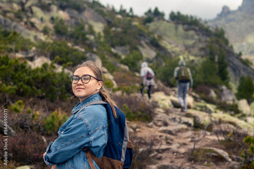 young woman is hiking with friends on mountain