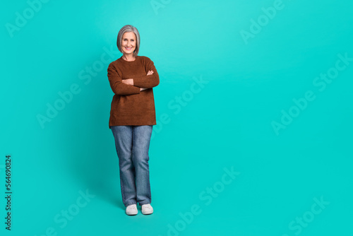 Full length photo of adorable glad retired lady wear brown stylish clothes demonstrate empty space isolated on cyan color background