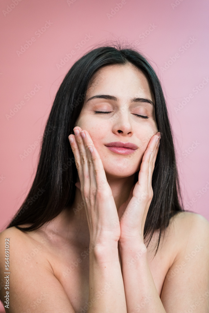 woman with makeup touching cheeks applying cream on face woman with makeup touching cheeks applying cream on face