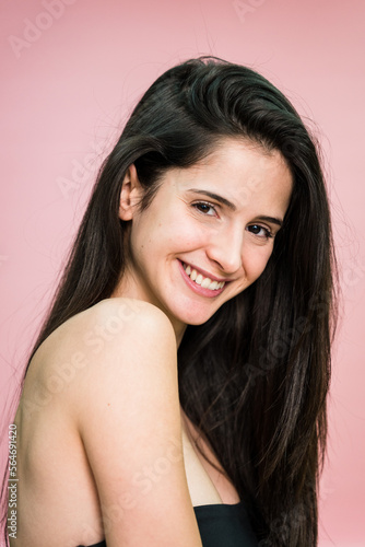 Wallpaper Mural Smiling woman with long hair looking at camera on pink background Torontodigital.ca