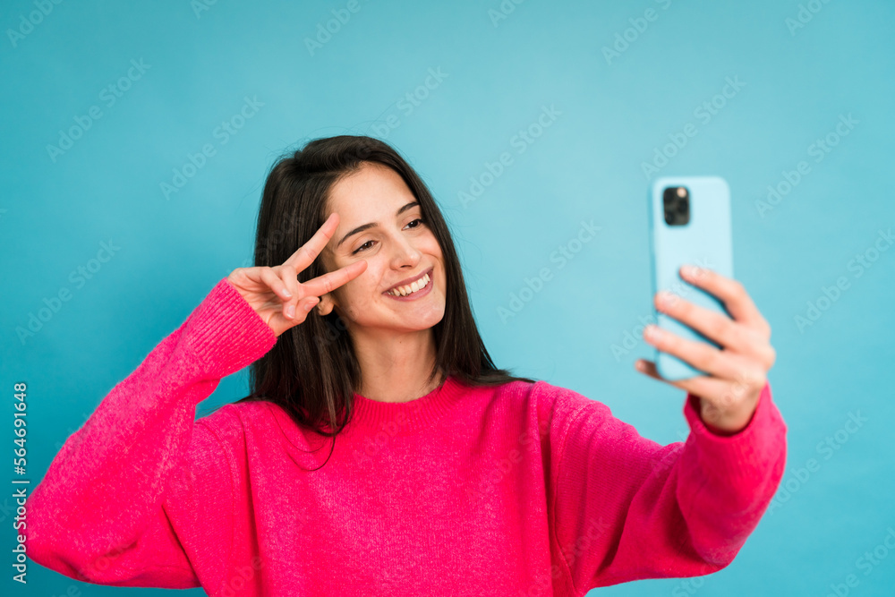Cheerful woman taking selfie on smartphone Cheerful woman taking selfie on smartphone