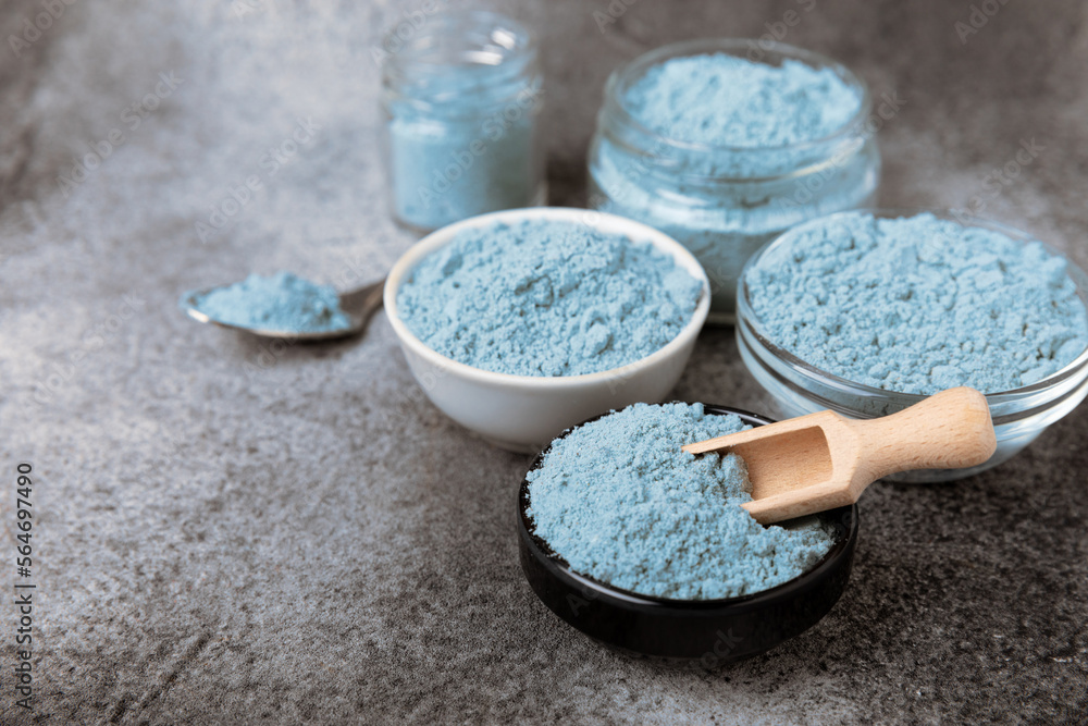 Blue spirulina powder in bowls and spoon on black marble background. Natural vegan superfood. food supplement. place for text. Copy space. Blue spirulina powder in bowls and spoon on black marble background. Natural vegan superfood. food supplement. place for text. Copy space.