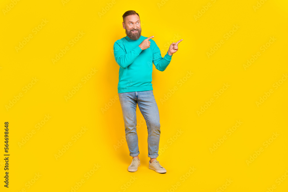 Full size photo of handsome granddad fingers point empty space interested wear trendy aquamarine outfit isolated on yellow color background Full size photo of handsome granddad fingers point empty space interested wear trendy aquamarine outfit isolated on yellow color background