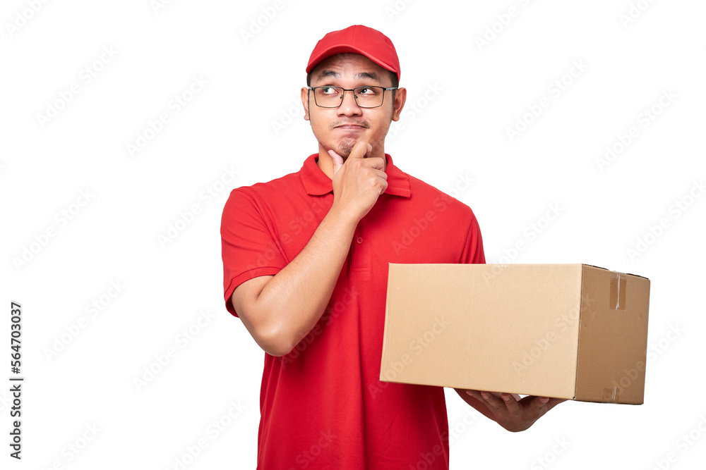 Thoughtful young asian male courier in red uniform, holding box with client order and thinking, looking upper left corner Thoughtful young asian male courier in red uniform, holding box with client order and thinking, looking upper left corner