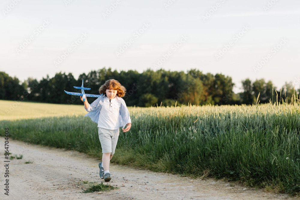 Happy boy holding airplane toy during running. High quality photo Happy boy holding airplane toy during running. High quality photo