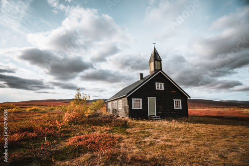 Black wooden church in Norway with a beautiful autumn landscape
