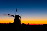 Windmills in the Netherlands. Historic buildings. Agriculture. Summer landscape during sunset. Bright sky and the silhouette of a windmill. Photography for design.