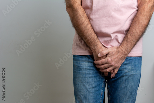 Sick man prostate cancer, prostate inflammation, premature ejaculation, fertility, erection or bladder problem. Man with hands holding his crotch, he wants to pee - urinary incontinence concept