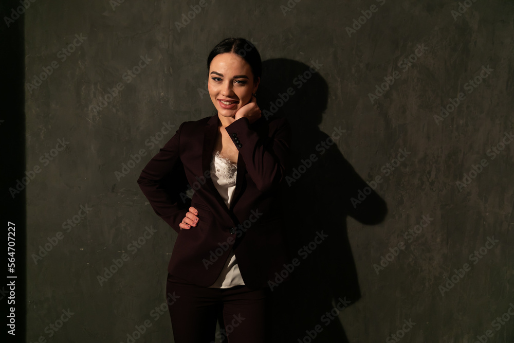 beautiful woman in a dark business suit in the office laughs