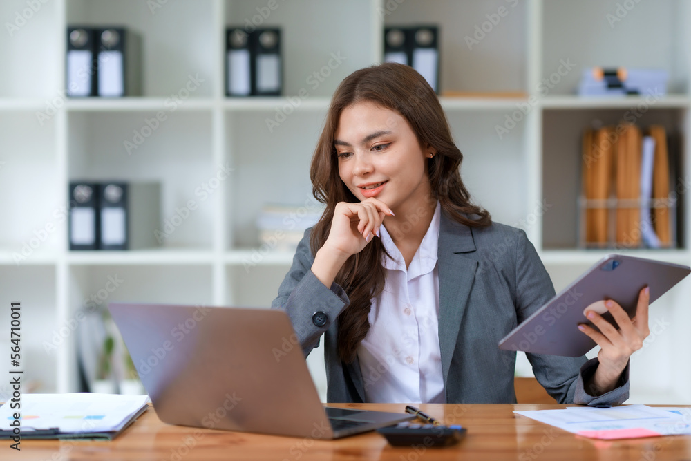 Smiling and attractive asian businesswoman enjoying working using laptop computer at office. Smiling and attractive asian businesswoman enjoying working using laptop computer at office.