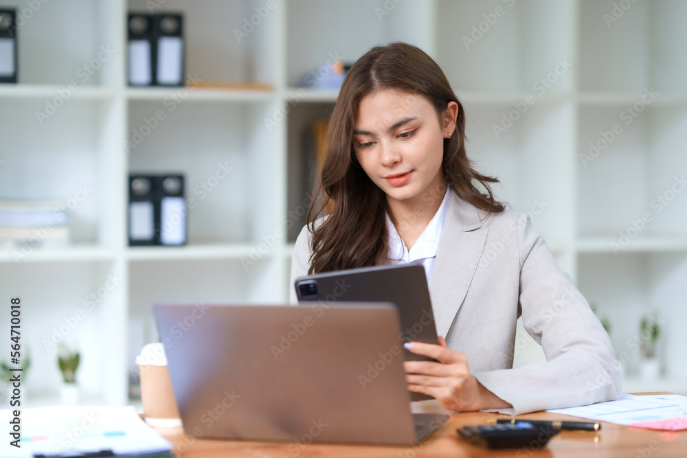 Smiling and attractive asian businesswoman enjoying working using laptop computer at office. Smiling and attractive asian businesswoman enjoying working using laptop computer at office.