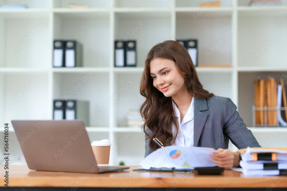 Smiling and attractive asian businesswoman enjoying working using laptop computer at office. Smiling and attractive asian businesswoman enjoying working using laptop computer at office.