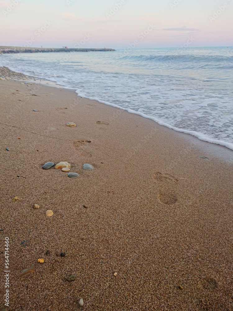Sandy beach of the sea. footprints in the sand. Twilight, Evening Sandy beach of the sea. footprints in the sand. Twilight, Evening