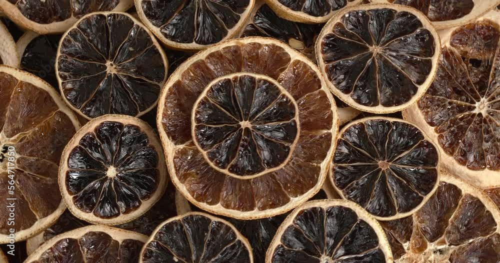 Dried orange, lemon and grapefruit slices background. Table spin.
