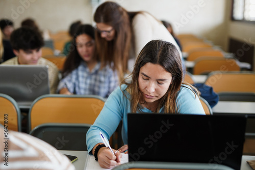 Young students learing inside university class room