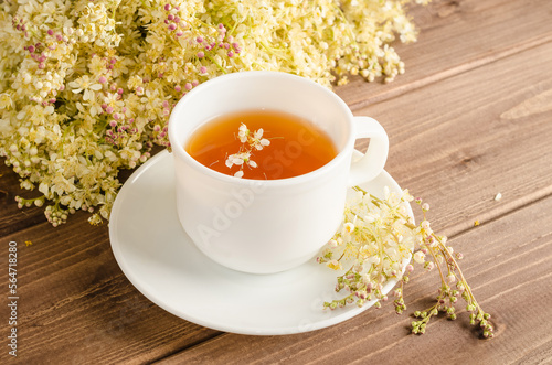 Schilderij op canvas Healthy herbal tea with meadowsweet in a white cup on a brown wooden background