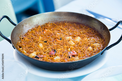 Fideua with squid and seafood. Typical Spanish tapa cooked with paella. photo