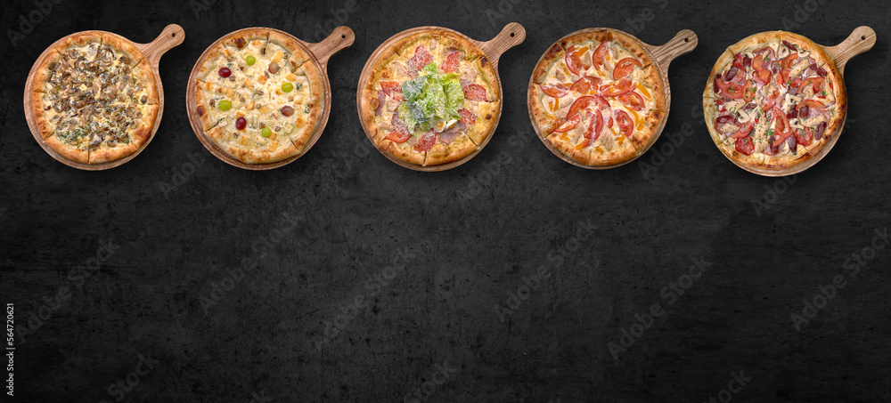 Pizza in assortment, on a wooden board, on gray concrete Pizza in assortment, on a wooden board, on gray concrete