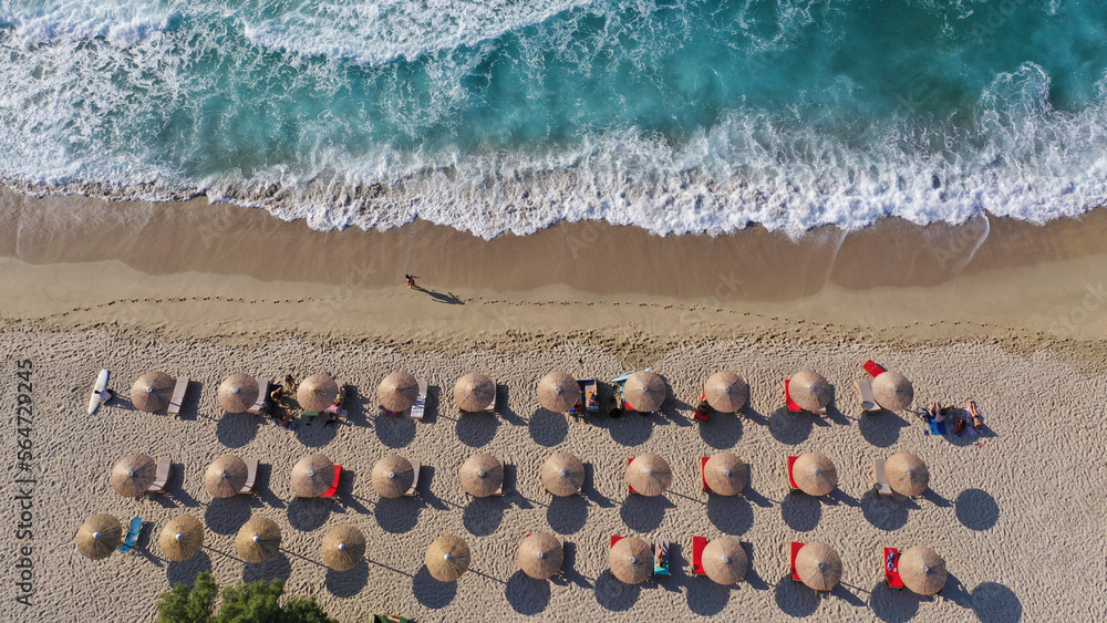 Aerial drone photo of famous for surfers organised with sun beds and umbrellas wavy beach of Armenistis in island of Ikaria, Aegean sea, Greece Aerial drone photo of famous for surfers organised with sun beds and umbrellas wavy beach of Armenistis in island of Ikaria, Aegean sea, Greece