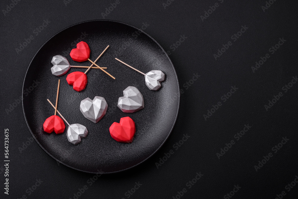Delicious sweet heart shaped chocolate candies on a dark concrete background Delicious sweet heart shaped chocolate candies on a dark concrete background