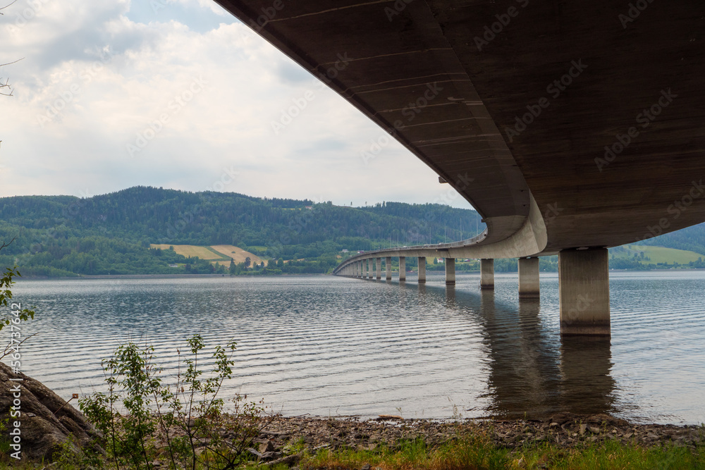 Brücke über den Mjøsa, Mjøsbrua, Provinz Innlandet in Norwegen. Bei der Ortschaft Moelv wird der See von der Straßenbrücke der E6 überquert. Der Pilgerweg St. Olavsweg führt unter der Brücke entlang.