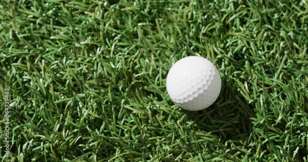 Close up of golf ball on grass, copy space, slow motion Close up of golf ball on grass, copy space, slow motion