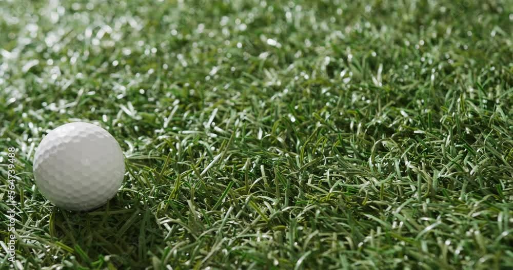 Close up of golf ball on grass, copy space, slow motion Close up of golf ball on grass, copy space, slow motion