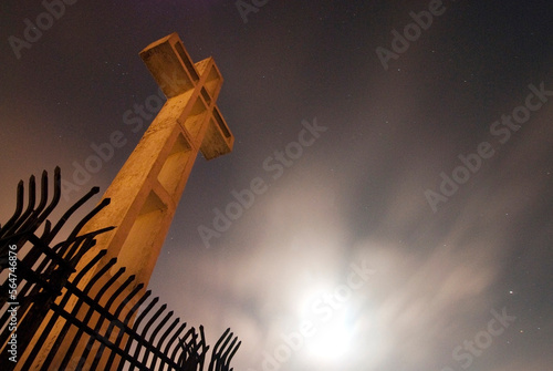 The cross on top of Mount Soledad is illuminated at night in La Jolla, CA. photo