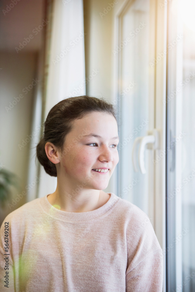 Girl looking out through window