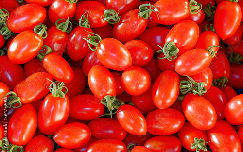 Bright red cherry tomatoes top view close up, natural vegan food background.