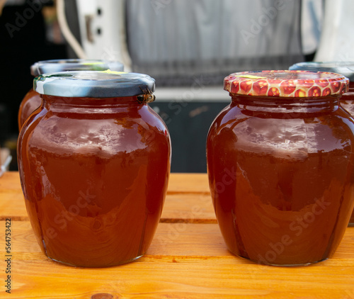 Obraz na płótnie Honey in glass jars. Sale of honey in transparent glass jars at the agricultural market. Close-up. Sale of beekeeping products. w salonie
