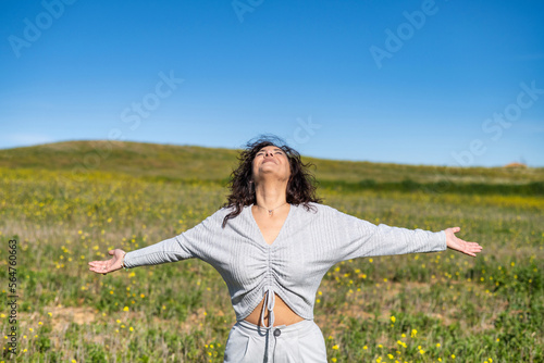 Front View Of A Beautiful Excited Woman Raising Her Arms And Breathing Fresh Air Celebrating Spring