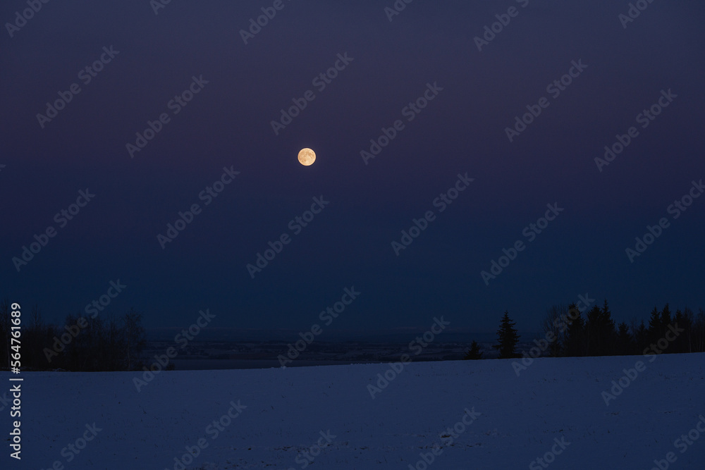 Fototapeta premium The full moon above Lake Mjøsa in winter.