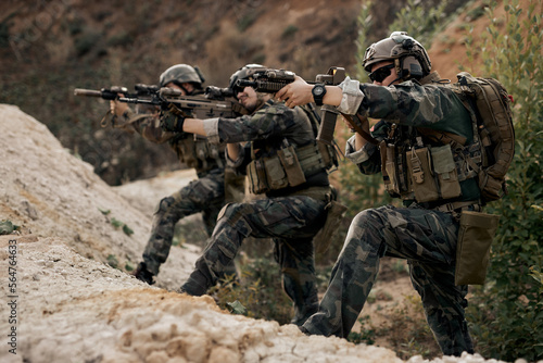 Tela Soldiers in special forces, Army soldier in protective combat uniform posing, looking at side holding special operations forces combat assault rifle, in protective combat uniform, soldiers engaged