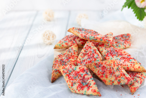 Homemade cookies with colored sugar on a light wooden background. 
