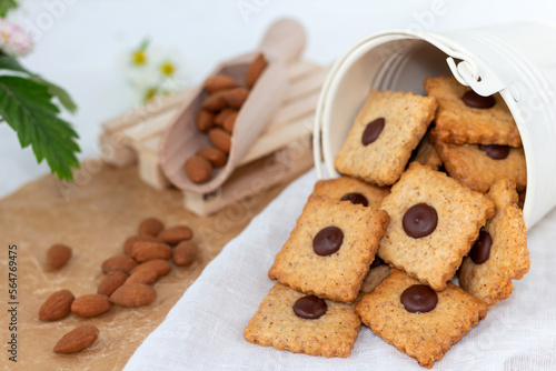 Cookies with almonds and chocolate with almond seeds on a light background. Beautiful homemade pastries. Selective soft focus.