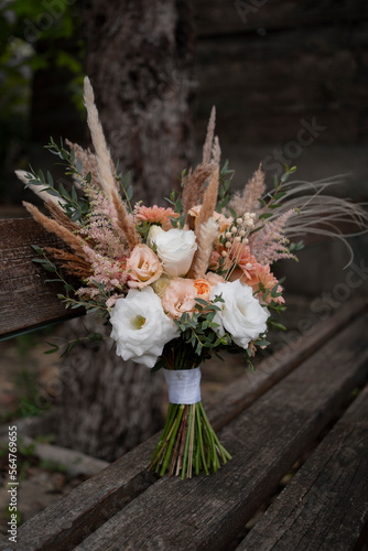 Beautiful wedding bouquet in vintage style. Boho bridal bouquet composed of lisianthus, pampas grass, roses and dried flowers. Wedding day.