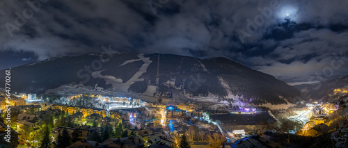 Panorama with El Tarter town. Hotels, resorts and residential buildings illuminated by street lights at night. Ski winter holidays, Andorra, Pyrenees