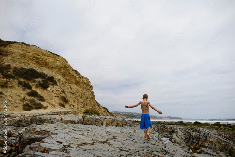 Rear view of boy at Corona del Mar beach against sky Rear view of boy at Corona del Mar beach against sky