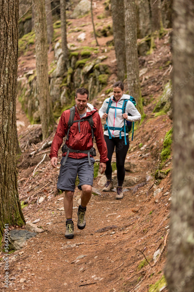 Couple hiking through forest on Beech Mountain in Acadia National Park, Maine, USA Couple hiking through forest on Beech Mountain in Acadia National Park, Maine, USA