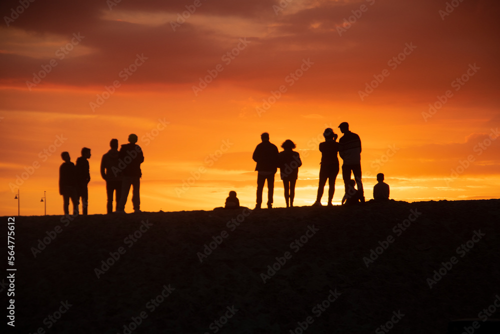 Group of people walking on the beach, enjoying the sunset in Venice Beach, Los Angeles, California, US. Group of people walking on the beach, enjoying the sunset in Venice Beach, Los Angeles, California, US.