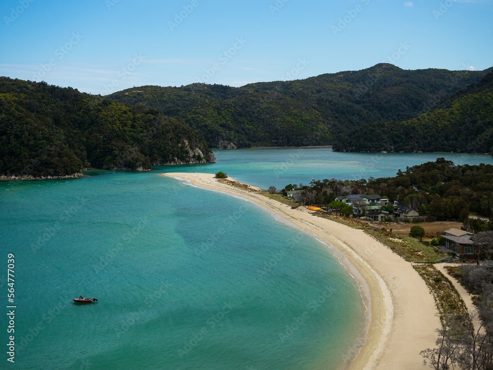 Elevated view of tropical pacific ocean beach surrounded by lush green nature in Abel Tasman National Park New Zealand Elevated view of tropical pacific ocean beach surrounded by lush green nature in Abel Tasman National Park New Zealand