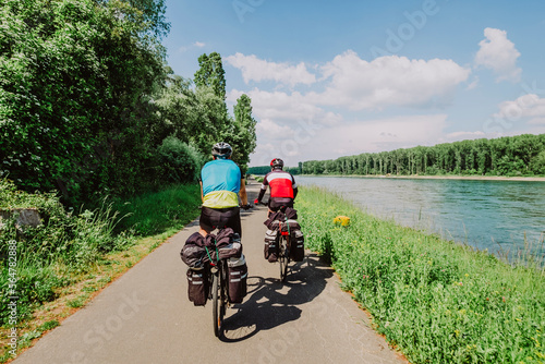 Two cyclists riding his bikes near to Rin River, Germany