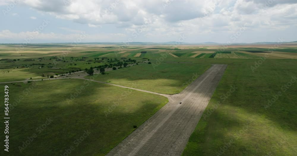 Car driving on wide runway of Shiraki military airfield in Georgia. Car driving on wide runway of Shiraki military airfield in Georgia.