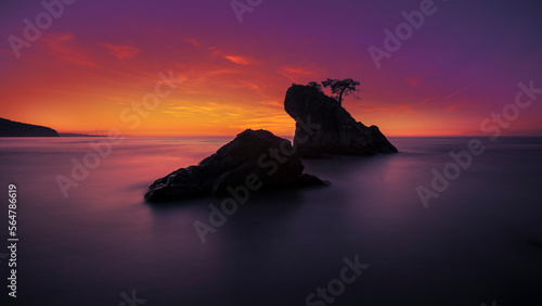 Fototapeta Naklejka Na Ścianę i Meble -  View of wooded rock of bartin inkumu beach with a long exposure low light photo, selective low exposure and saturated sunset colors at horizon
