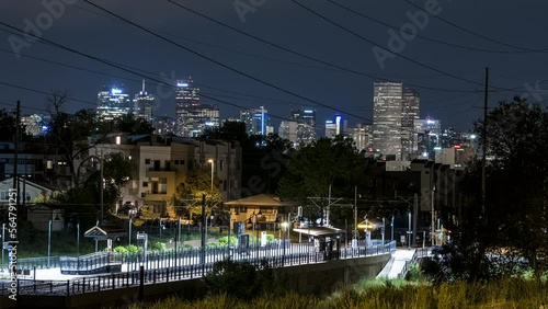 Time lapse of a suburban Denver RTD rail system stop at night with the downtown skyscrapers off in the distance. photo