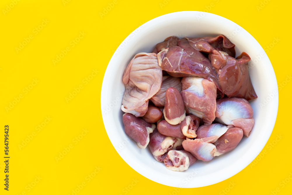 Mixed chicken entrails in white bowl on yellow background. Mixed chicken entrails in white bowl on yellow background.